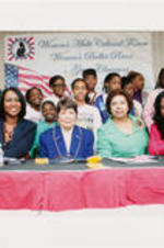 Evelyn G. Lowery is shown with two unidentified women, Sheryl Lee Ralph (on right), and young girls during a Women's Multi Cultural Forum. Written on verso: 2008