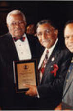 Southern Christian Leadership Conference (SCLC) President Joseph E. Lowery and Walter E. Fauntroy are shown presenting an award to Reverend Curtis Harris at the 35th Annual SCLC Convention in Dayton, Ohio.
