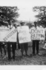 Demonstrators are shown holding protest signs as part of a march to protest the killing of the Russaw brothers by police in Eufaula, Alabama.