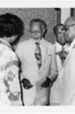 Clarence Bacote attends a retirement dinner. Written on verso: Dr. Clarence A. Bacote. August, 1977. Prof. of History- Chmn. Of Hist. Dept. Sen. Of Arts + Sci's. [Testimonial dinner on the occasion of his retirement from A.U.]