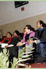 Platform participants (President, Board of Trustees, and Deans) listen to a speech.