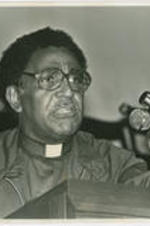 Joseph E. Lowery preaching and pointing with his left hand while standing at a podium.  Written on verso: Young Joseph Lowery preaching on pilgrimage 1979.