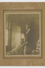 A man and two women seated at a window. Written on verso: Congratulations, Ella M. Webster, Avery Webster, Edgar H. Webster.