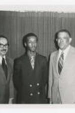 President Henderson and two other men pose at an event.