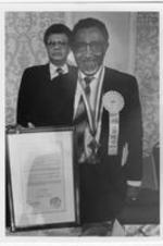 Southern Christian Leadership Conference (SCLC) President Joseph E. Lowery holds a framed proclamation during the 29th Annual SCLC Convention in Jacksonville, Florida. Claud Young stands behind Lowery.