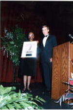 Dr. Roslyn Pope holds an award with an unidentified man at the Atlanta Student Movement 20th anniversary event.