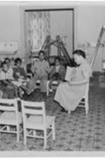 A group of children sit and listen to story time with a teacher at the Bethlehem Community Center.
