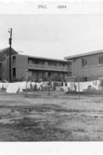 Clothes hang on line outside of the ITC apartments. Written on verso: ITC student apartments, 1967.