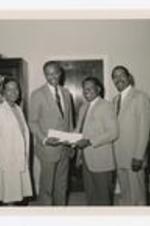 Dr. Thomas Cole and others pose with a check.