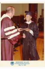 President Hugh Gloster presenting degree to unidentified graduate.