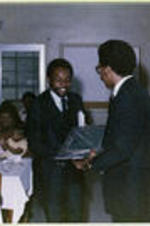 An award is presented to an unidentified man by Howard Robinson at the 1979 senior breakfast.