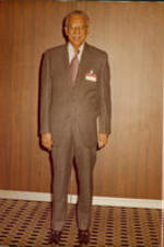 Dr. Brailsford R. Brazeal wearing a suit and tie and a nametag.