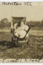 Outdoor portrait of infant James A. Patrick in a carriage; written on recto: 12 months old, I am so fat until I can't sit up.