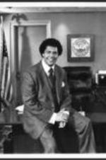 Maynard Jackson sits on a desk in his mayor's office.