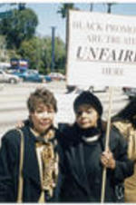 Evelyn G. Lowery poses for a photo with Evelyn Occhino holding a protest sign outside of the Creative Artists Agency in Beverly Hills, California.