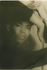 Portrait of Alvin Ailey with his arms wrapped around his head. Written on verso: Alvin Ailey; Photograph by Carl Van Vechten; 146 Central Park West; Cannot be reproduced without permission; March 22, 1955.