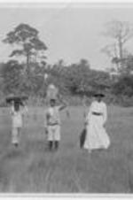 Anna E. Hall and boys standing in a field in Liberia. Written on verso: Miss Hall &amp; Mission Boys.