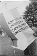 SCLC North Carolina Chapter Field Secretary Golden Frinks is shown holding a Southern Christian Leadership Conference banner. Written on verso: Mr. Golden Frinks: SCLC Field Director. Catur [Decatur], Ala. June, '80