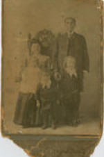 A portrait of a man and woman with three children posing for a picture.