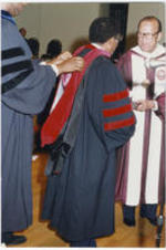 Joseph E. Lowery is shown being hooded during a commencement ceremony at Morehouse College. Dr. Hugh Gloster stands at right in the photograph.