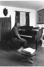 C. Eric Lincoln sits and plays at his piano in his home.