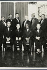A group portrait of members of the Sigma Pi Phi Fraternity. Extraneous note: Dr. Rufus Clement (seated 1st from right), [?] Hackney (standing 3rd from left), Whitney Young (standing 5th from left), J. B. Blayton (standing 3rd from right), [?] Milton (standing 1st from right), A. T. Walden (seated 3rd from right), B. R. Brazeal (seated 3rd from left), Clarence Baycote (standing 4th from left), Albert Manley (standing 5th from right), Benjamin E. Mays (standing 4th from right), James Brawley (seated 4th from right).
