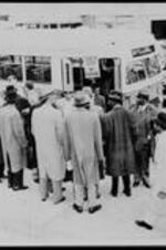 Written on accompanying slide: From Atlanta. Negroes Leave Bus After Mixed Ride. Negro clergymen stand around the front door of a public bus in Atlanta just after riding it with disregard for segregated seating regulations. When they began getting off, the driver asked them to leave by rear door. They declined and alighted through the front door. during their ride of about 36 blocks, some occupied seats up front with white passengers seated behind them. That's contrary to transit company regulations.