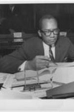 Georgia state senator Leroy Johnson is shown sitting in the Senate chambers at the Georgia State Capitol. Caption on photo reads: (AX1) ATLANTA, May 21 - LONE NEGRO SENATOR WINS VOTER AMENDMENT APPROVAL - Leroy Johnson of Atlanta, only Negro member of the Georgia State Senate, won adoption of an amendment Wednesday that would permit registrars to approve as voters any who answer correctly four of six questions. The amendment, which must have House approval, was substituted for a section of a proposed revision of the state's election code. The previous section called for 20 correct answers from illiterates of 30 questions. Johnson's amendment would add thousands of Negroes to registration rolls in Georgia.