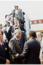 Southern Christian Leadership Conference President Joseph E. Lowery greets Nelson Mandela as he disembarks from an airplane. Atlanta Mayor Maynard Jackson is second from left in the photo.