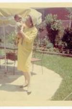 Unidentified woman holding Beth A. Chandler on a patio. c 1967. 9 1/2 m.
