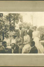 George A. Towns sits outside with a group of men and women.