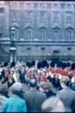 Queen's Guard carrying riffles and flag in Front of Buckingham Palace gate.