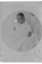 An unidentified baby in a white gown.