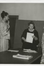 Three unidentified Alabama women are shown being sworn-in by another unidentified woman.