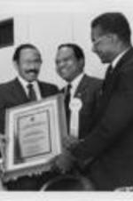 U.S. Representative John Conyers (second from left) is shown receiving the Adam Clayton Powell Congressional Leadership Award with (from left to right) Southern Christian Leadership Conference (SCLC) President Joseph E. Lowery, Walter E. Fauntroy and Fred Shuttlesworth. Conyers was recognized with the award at the 30th Annual SCLC Convention in New Orleans, Louisiana. Written on verso: Congressman John Conyers receives the SCLC Adam Clayton Powell Congressional leadership award. Lowery, Fauntroy and Shuttlesworth join him for a group picture.