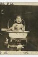 Indoor portrait of infant James A. Patrick in washtub; written on recto: 12 months old, taking a bath.