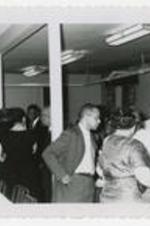 A group of men and women in conversation at a party.