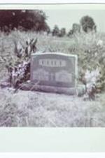 A headstone surrounded by flowers. The name on the headstone reads "Clift."