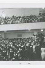 Graduates sit in the audience in a auditorium at commencement.