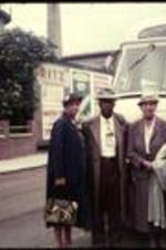 Levi and Jewell Terrill stand with two other unidentified women in front of a charter bus.