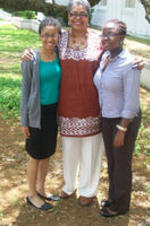 Two Spelman SIS students stand with Dorothy Smith under a large live oak tree.