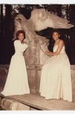 Outdoor portrait of 2 woman with concrete bird sculpture. Written on verso: "L to R- Michelle Patmon- Miss Morris Brown College, Phyllis Hall First attendant to Miss Morris Brown. 1984-85".