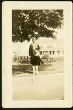 Portrait of Mrs. Watman standing in front of a house. Written on verso: Mrs. Watman, a music teacher at Morehouse.