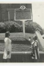 Exterior view of women in front of the historic site sign of Bethel AME Church.