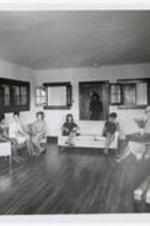 Students sit on a sofa and chairs in the student lounge of Chadwick Hall.