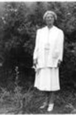 Louise Allyn stands in a yard in front of a birdbath. Written on verso: Mrs. Allyn, Principal of Trinity School, Athens, Alabama for 30 years. Commencement Sunday, 1939.