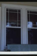 A close up view of a craftsman bungalow's windows. Text from slide presentation: windows with several small panes of glass in the top sash,