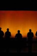Silhouette view of actors on stage.