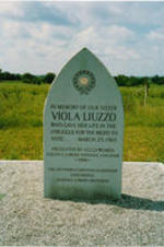 A picture of Viola Liuzzo's memorial monument, a site visited during SCLC/W.O.M.E.N. Civil Rights Heritage Tours, in Lowndes County, Alabama. The monument is vandalized, with the words "a white Yankee whore" written at the bottom of the monument.
