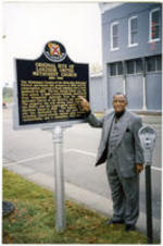 Joseph E. Lowery points to a historical marker sign with information about Lakeside United Methodist Church in Huntsville, Alabama.